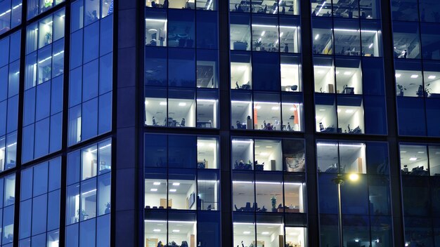 Fragment of the glass facade of a modern corporate building at night