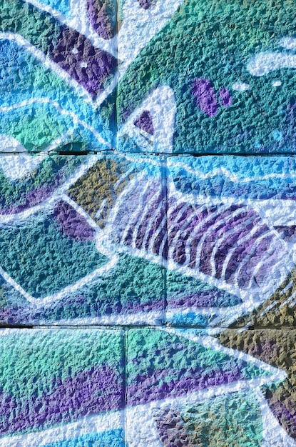 Fragment of graffiti drawings The old wall decorated with paint stains in the style of street art culture Colored background texture in cold tones