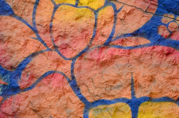 Fragment of graffiti drawings the old wall decorated with paint\
stains in the style of street art culture orange flower