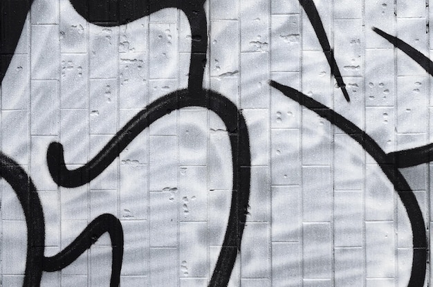 A fragment of a graffiti pattern applied to a wall of cold tiles which is covered with a fine condensate The concept of street art in inappropriate weather