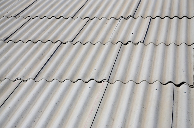 A fragment of a gray slate roof of an old sample made of asbestos material