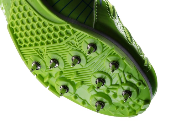 Fragment of a green glossy sneaker with spikes on a white background Sport shoes