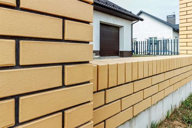 Fragment of a modern fence lined with decorative bricks in the old style