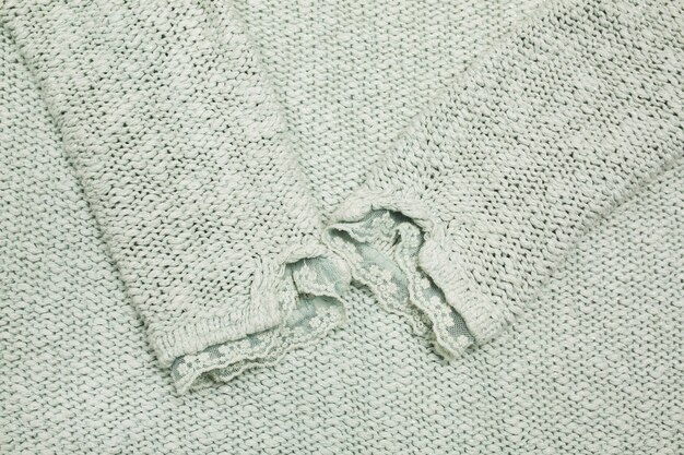 Фото Фрагмент вязанного свитера бирюзового цвета с кружевом. снимок крупным планом