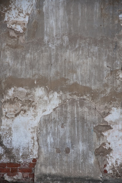 콘크리트 석고가 있는 오래된 벽돌 벽 조각과 여러 가지 빛깔의 페인트 잔해