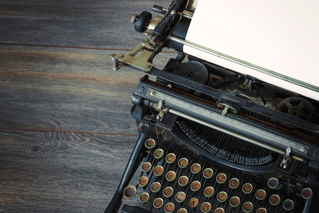 Foto frammento di una vecchia macchina da scrivere con un foglio di carta bianco