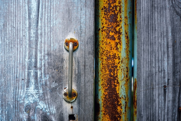 녹슨 금속 손잡이와 오래 된 나무로되는 문의 조각