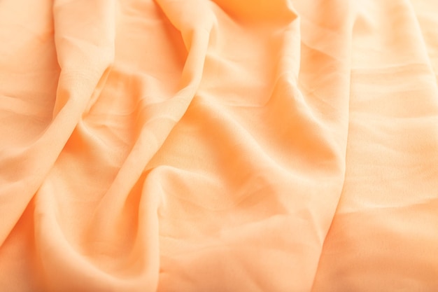 Фрагмент оранжевой льняной ткани, вид сбоку на натуральный текстильный фон