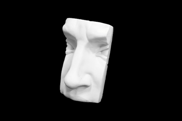 Photo fragment of plaster sculpture of a human face isolated on black background. high quality photo