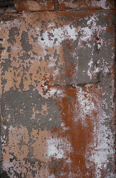 오래된 페인트와 시멘트 층이 있는 회반죽 벽돌 벽 조각