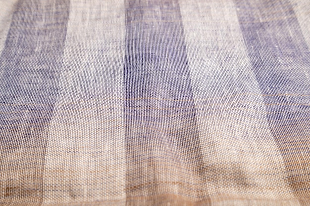 Fragment of smooth brown and violet linen tissue Side view natural textile background