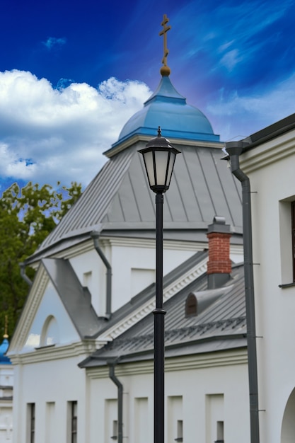 Fragment van de klokkentoren van een christelijke kerk met een blauw dak. Kerkklokkentoren tegen de hemel