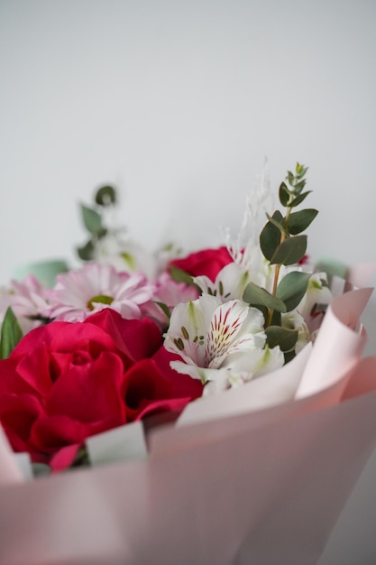 Foto fragment van een boeket rozen en alstromeria.