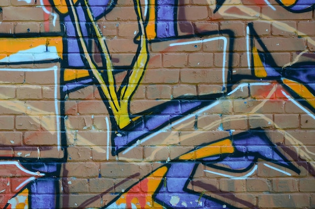 Fragment van graffititekeningen De oude muur versierd met verfvlekken in de stijl van straatkunstcultuur Gekleurde achtergrondstructuur in warme tinten