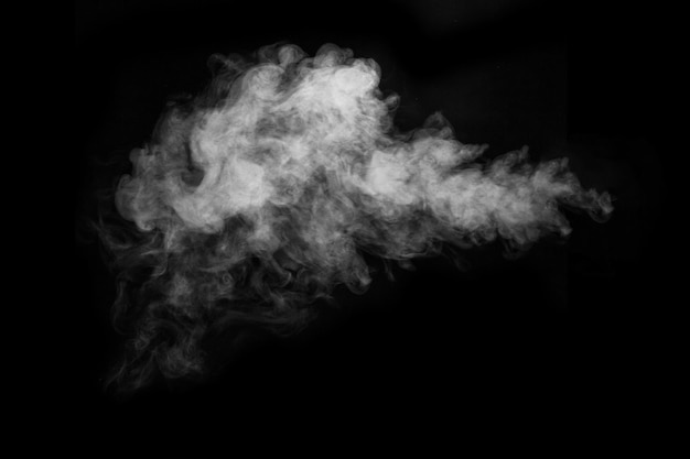 黒い背景に分離された白い熱い巻き毛の蒸気煙の断片、クローズアップ。神秘的なハロウィーンの写真を作成します。抽象的な背景、デザイン要素