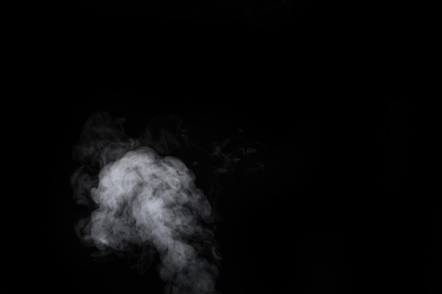 Fragment of white hot curly steam smoke isolated on a black\
background, close-up. create mystical halloween photos. abstract\
background, design element