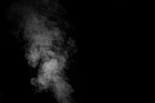 Fragment of white hot curly steam smoke isolated on a black background, close-up. Create mystical photos. Abstract background, design element