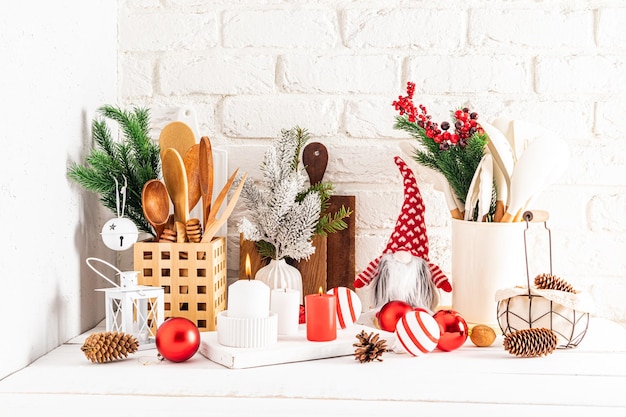 자신의 손으로 만든 현대적인 스타일의 다양한 주방 용품과 크리스마스 장식이 있는 흰색 나무 주방 조리대 조각