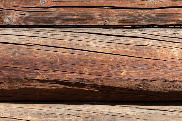 Fragment of a wooden house. Wooden wall from logs as a background texture