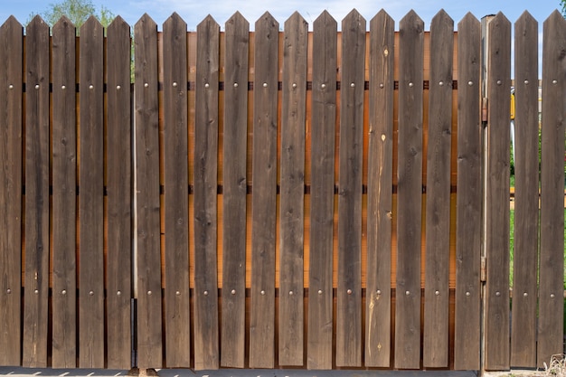 Fragment of a wooden plank fence with metal rivets. Security concept. Background with copy space.