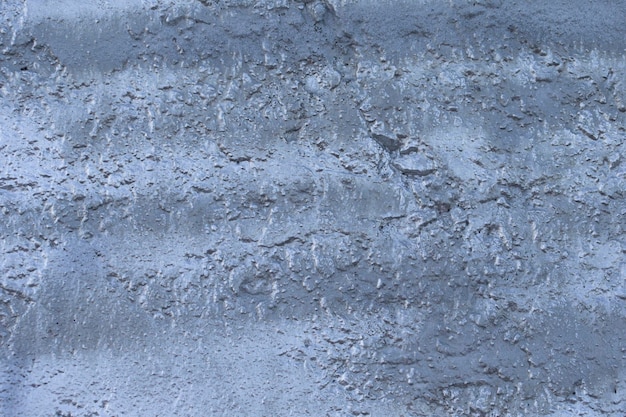 Fragmenten van een betonnen muur beschilderd met metallic zilververf