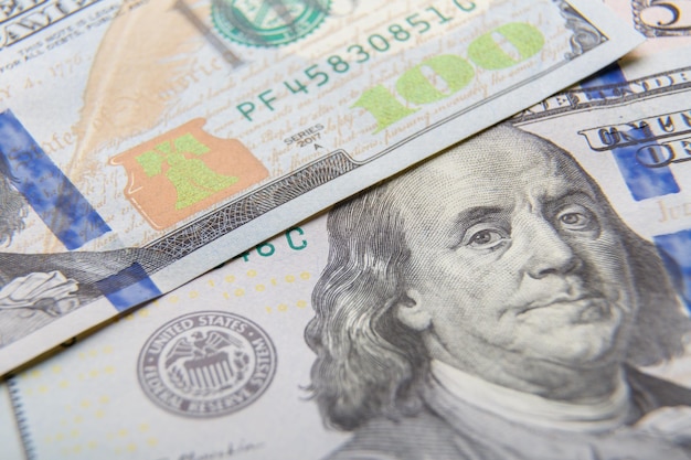 Fragments of dollar bills of different denominations on a flat surface a very closeup