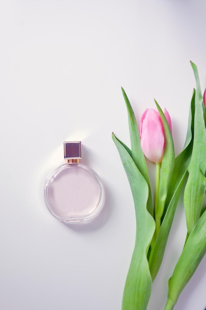 香水の香りとピンクのチューリップロマンティックコンポジションボトルと封筒はがきのデザイン