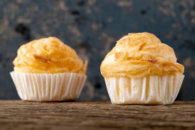 Foto crostini di mandorle fragranti con ripieno di crema pasticcera su sfondo di legno rustico cruffin è ibrido di croissant e muffin