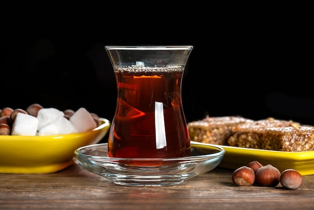 Foto tè nero profumato in un bicchiere e con shaki halva