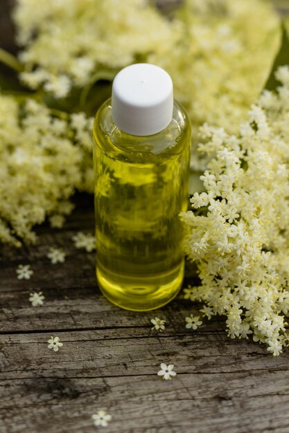 The fragrant elderberry flower with essential oil on a wooden table