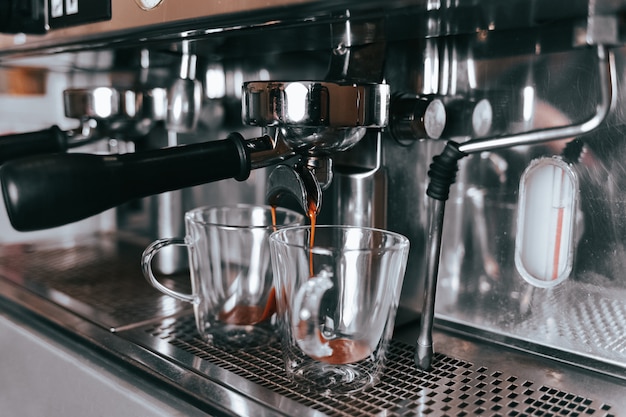 Fragrant espresso flows from a coffee machine into a cup.