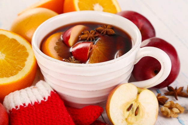 Fragrant mulled wine in bowl on wooden table close-up