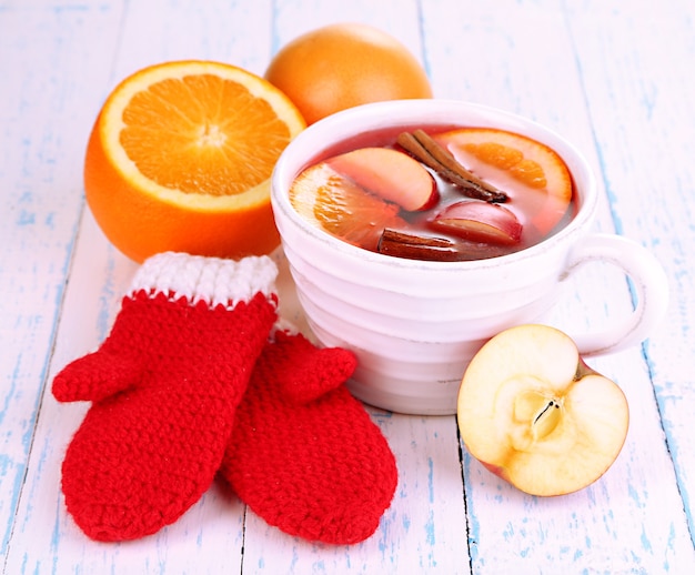 Fragrant mulled wine in bowl on wooden table close-up