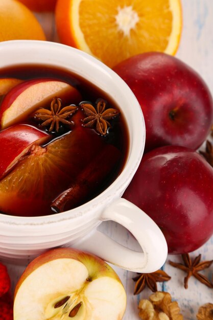 Fragrant mulled wine in bowl on wooden table close-up