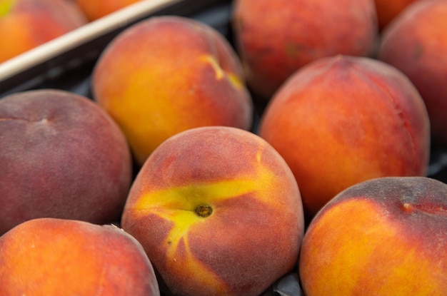 Fragrant ripe nectarine on market tray or box. For food illustration, agriculture purpose