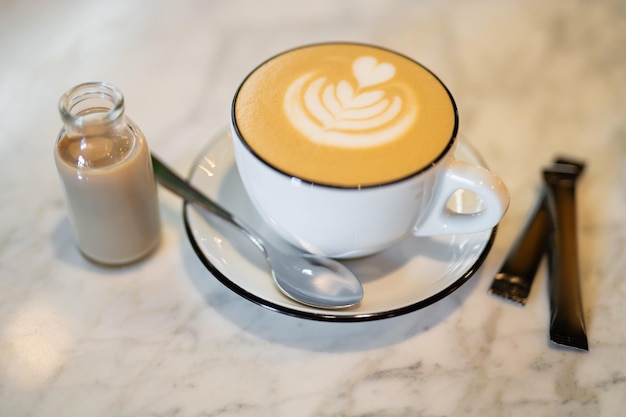 A fragrant and warm mug of cappuccino with a drawing heart on table