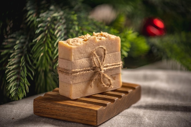 Fragrant yellow piece of natural soap on an organic wooden soap dish