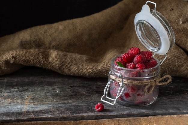 Framboos in een glazen pot. Raspberry achtergrond. Gezond eten. Verse biologische bessen. veget