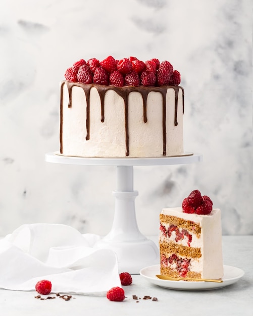 Frambozencake Frambozenbiscuitgebak met verse frambozen en zure room op een witte achtergrond