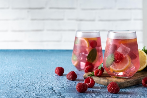 Frambozenlimonadedrank in glas op blauwe achtergrond