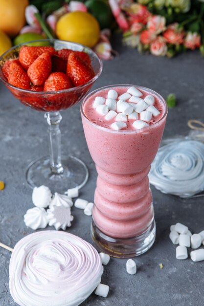 Frambozensmoothie met gekleurde marshmallows en bessen.