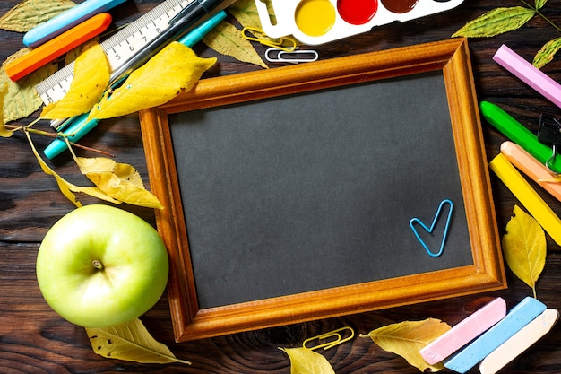 Frame Back to school Table with autumn leaves apple  and school supplies Top view