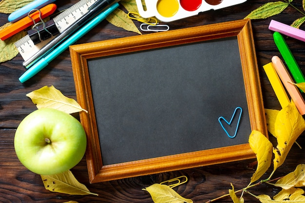 Frame Back to school Table with autumn leaves apple  and school supplies Top view