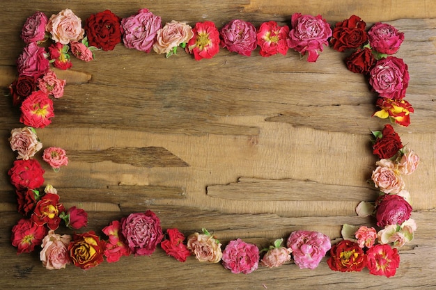 Cornice di bellissimi fiori secchi su fondo di legno