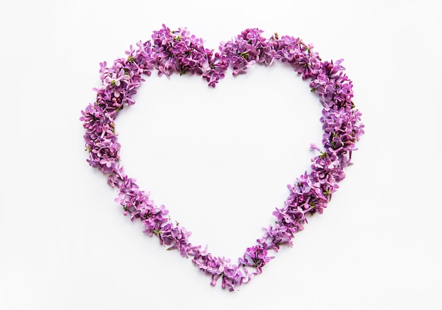 Frame of branches and flowers of lilac in the shape of a heart