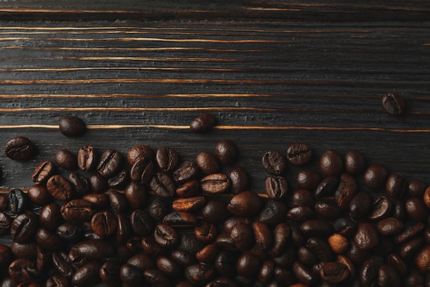 Frame of coffee beans on wooden background, space for text