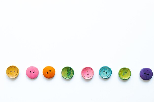 Frame of colorful sewing buttons isolated on white