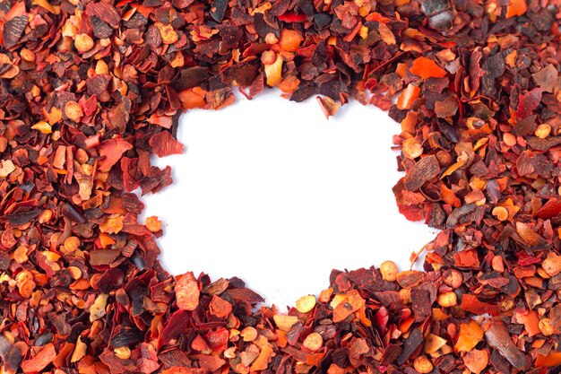 Frame of crushed red chilli pepper, dried cayenne pepper flakes isolated on white background with copy space