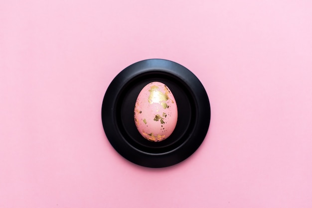 Frame of Easter golden decorated eggs on pastel pink background.  