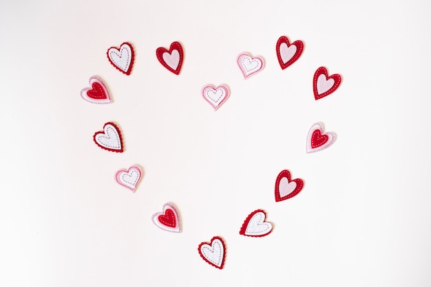 Frame of felt hearts on a white background with copying space